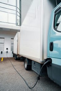 Camion poids lourd électrique en cours de recharge à une station moderne, illustrant la transition énergétique dans le transport routier by neomproject.fr